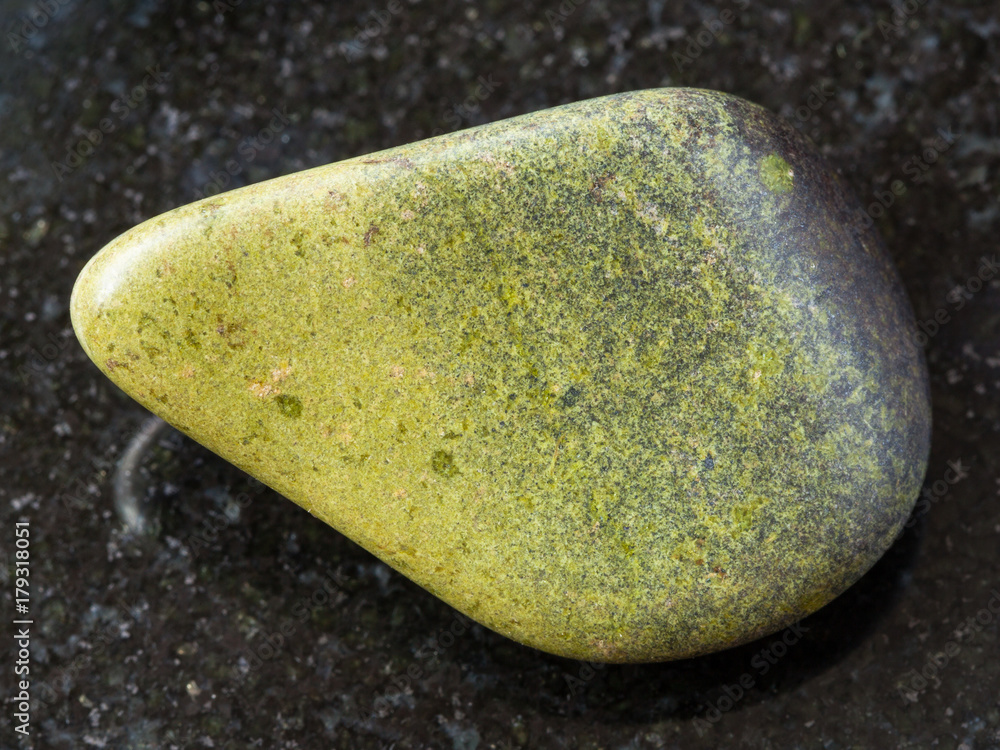 tumbled epidote gemstone on dark background tumbled epidote gemstone on dark background