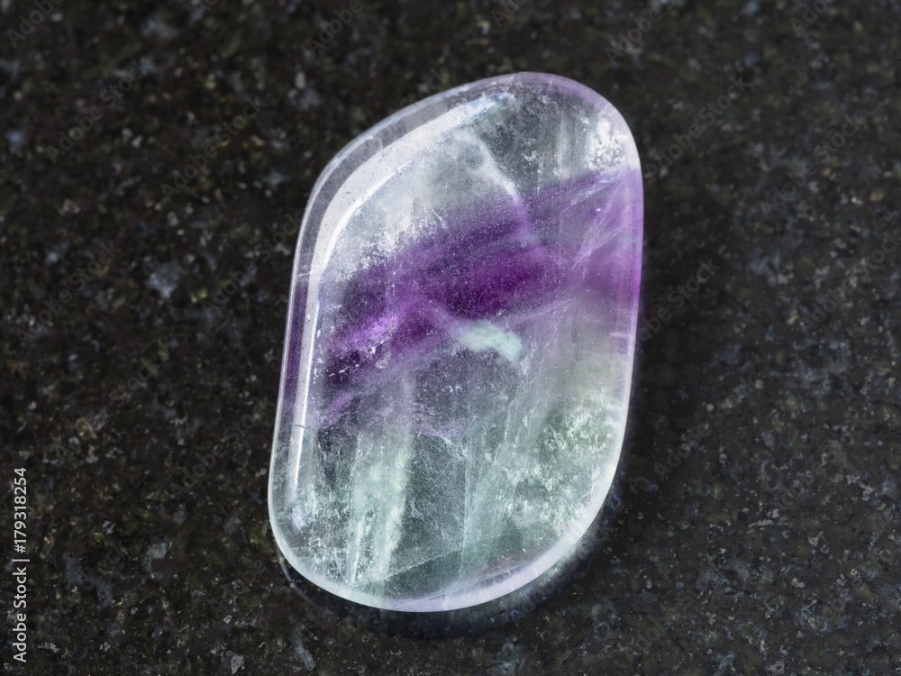 polished Fluorite gem stone on dark background polished Fluorite gem stone on dark background