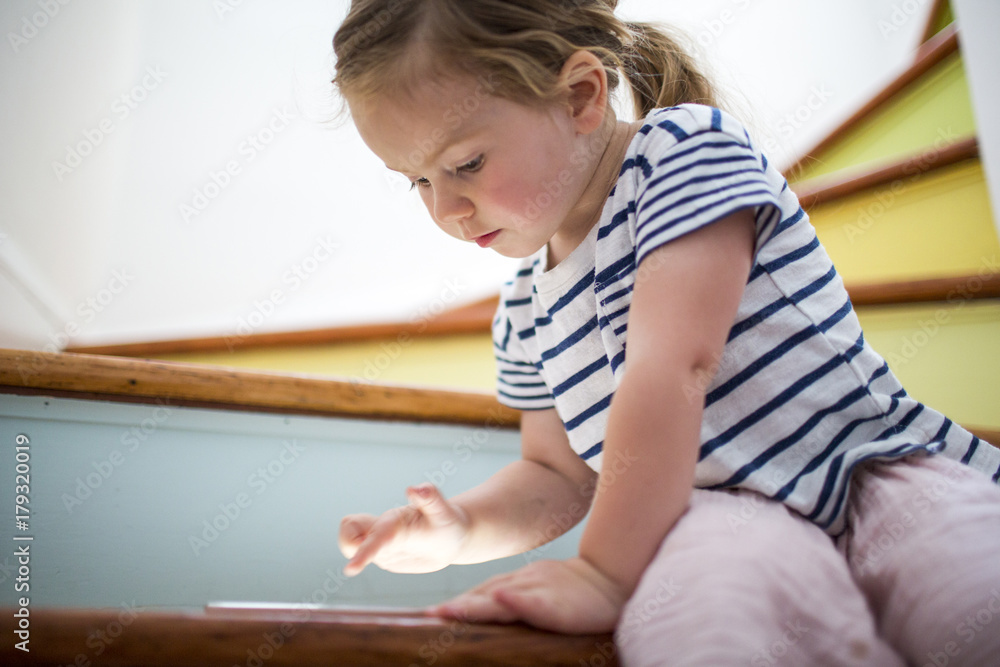 Girl using digital tablet on staircase Girl using digital tablet on staircase