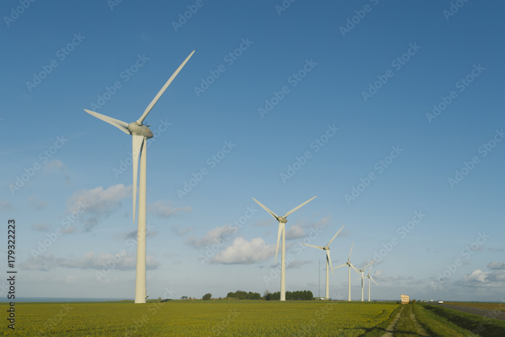 Wind turbines of a power plant for electricity generation in Normandy, France. Concept of renewable sources of energy. Environmentally friendly electricity production. Toned Wind turbines of a power plant for electricity generation in Normandy, France. Concept of renewable sources of energy. Environmentally friendly electricity production. Toned