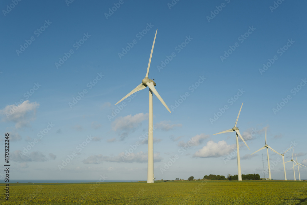 Wind turbines of a power plant for electricity generation in Normandy, France. Concept of renewable sources of energy. Environmentally friendly electricity production. Toned Wind turbines of a power plant for electricity generation in Normandy, France. Concept of renewable sources of energy. Environmentally friendly electricity production. Toned