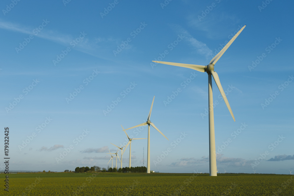 Wind turbines of a power plant for electricity generation in Normandy, France. Concept of renewable sources of energy. Environmentally friendly electricity production. Toned Wind turbines of a power plant for electricity generation in Normandy, France. Concept of renewable sources of energy. Environmentally friendly electricity production. Toned