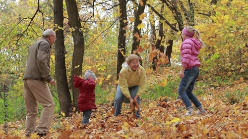 Grandparents and kids having fun in autumn park photo