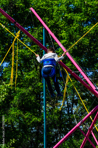 Little boy playing on bungee trampoline