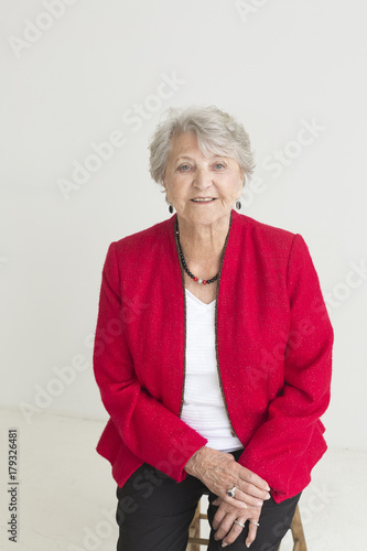 Portrait of older Caucasian woman sitting on stool photo