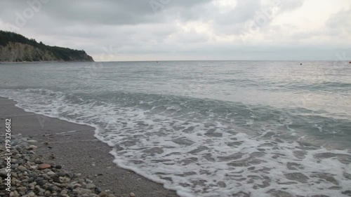 Strong waves crash over the beach photo