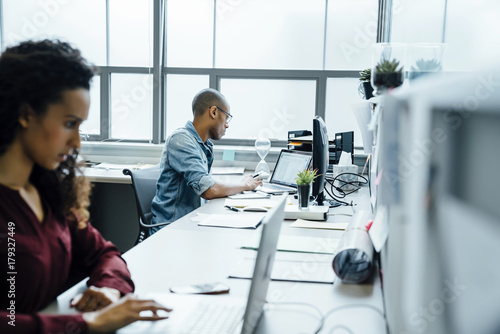 Business people using laptops in office