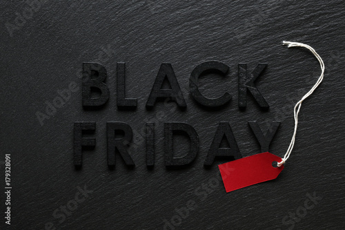 Black Friday text with red sale tag on slate background