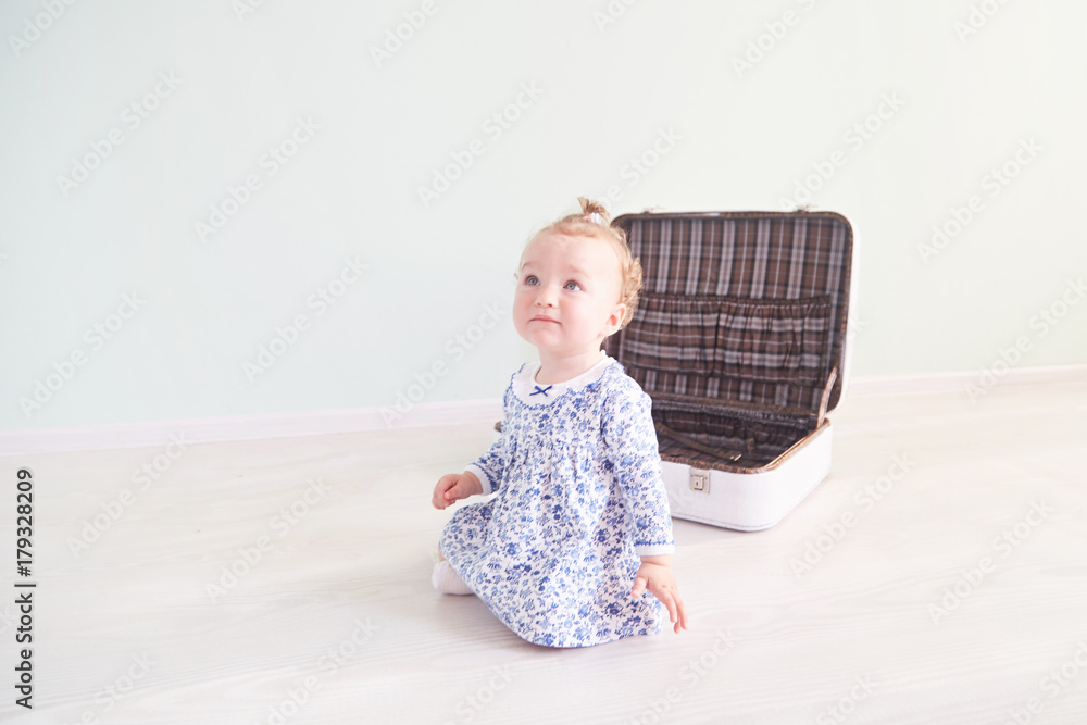 little girl is playing with a white suitcase little girl is playing with a white suitcase