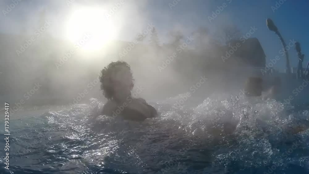 Young woman relaxing in the thermal spa water pool outdoors, SLOW MOTION Young woman relaxing in the thermal spa water pool outdoors, SLOW MOTION