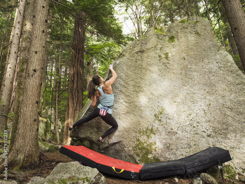 Mixed race girl climbing rock