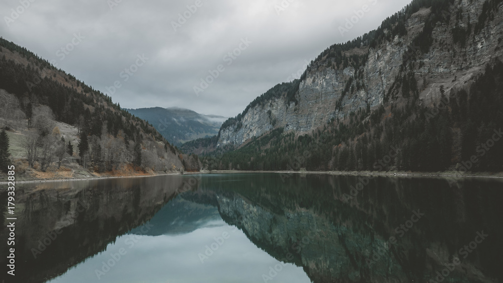 Wide angle view of Montriond Lake on a rainy day, mountains in the background. French Alps