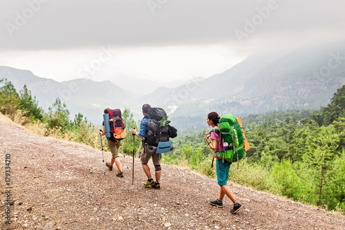 A group of three modern tourists backpackers travels in the summer along the Lycian Way in Turkey