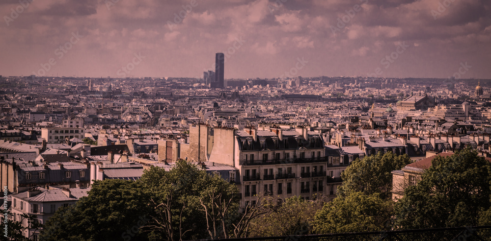 Paris rooftops at dusk from elevation at Montmartre with Montparnasse Tower in the distance