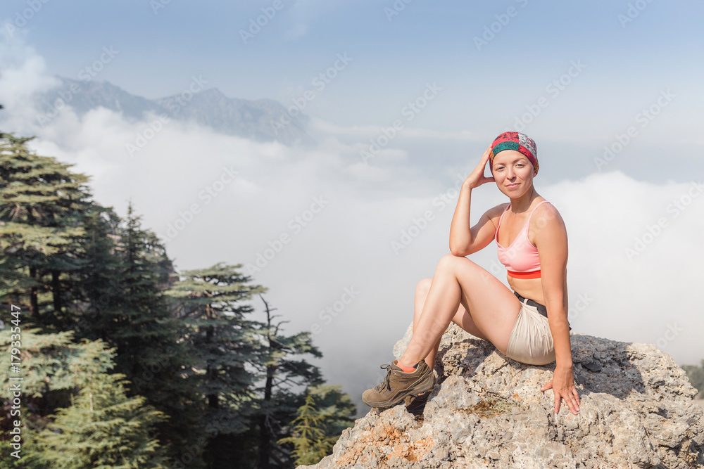 Obraz premium Healthy and fit Woman in shorts at the top of the mountain, travel and adventure concept