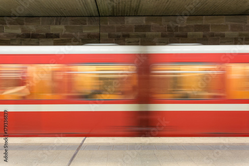 Moving red and white subway in the underground going past