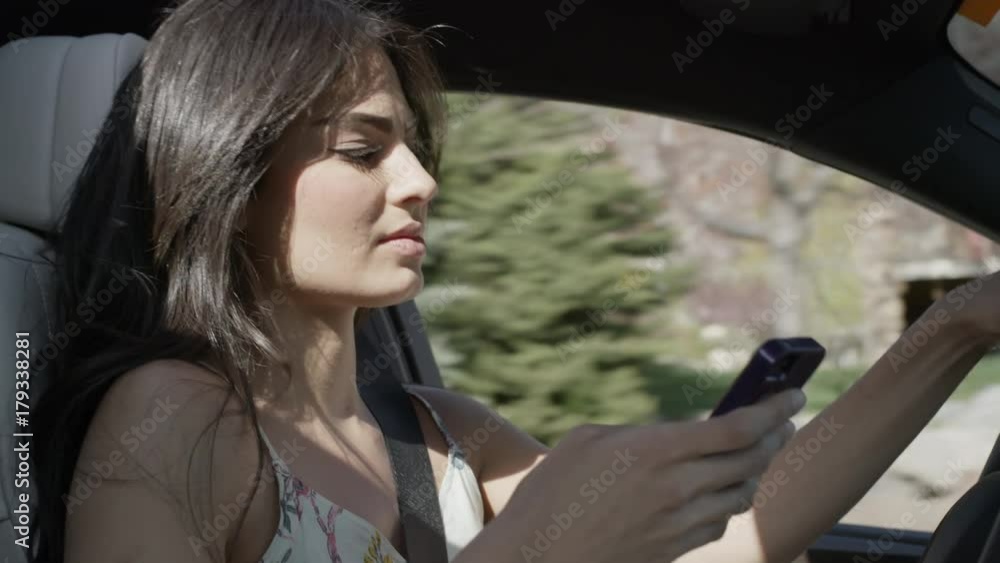 Close up of woman driving distracted with cell phone / Cedar Hills, Utah, United States