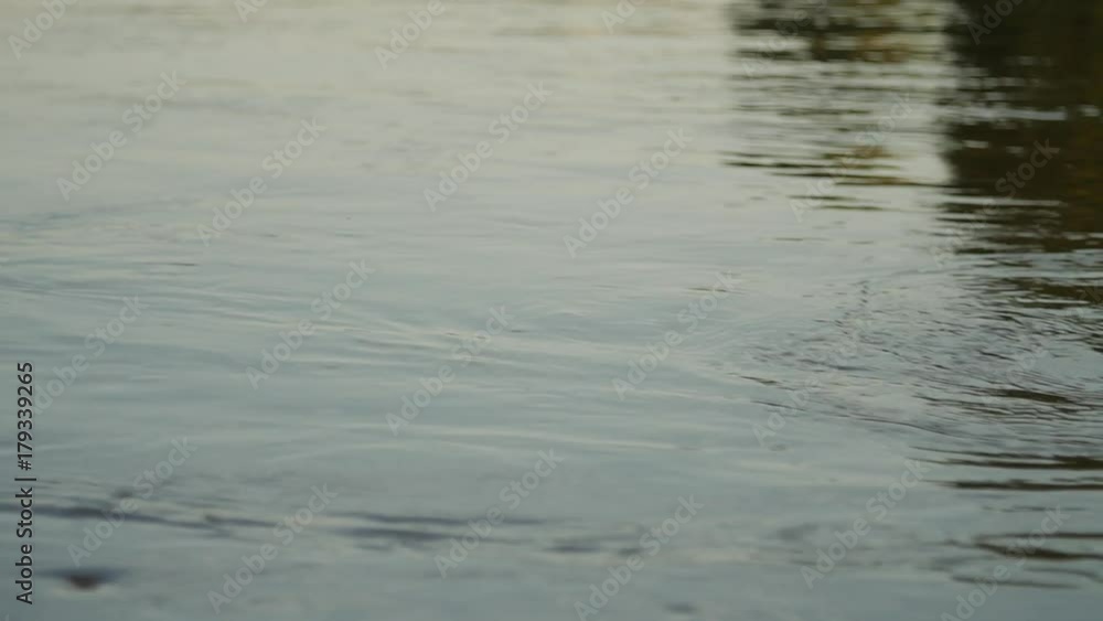 River water surface. Close-up of texture of nature works ripples on the water. Background meditative and hypnotic effect. River water surface. Close-up of texture of nature works ripples on the water. Background meditative and hypnotic effect.