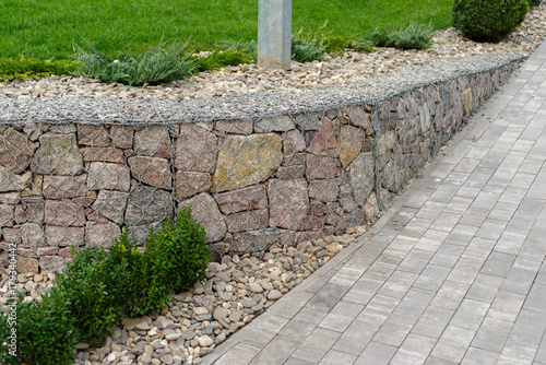 Natural stone with a metal mesh near the lawn in the landscape design