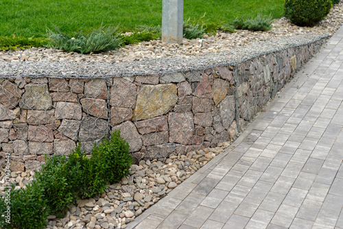 Принти на полотні Natural stone with a metal mesh near the lawn in the landscape design
