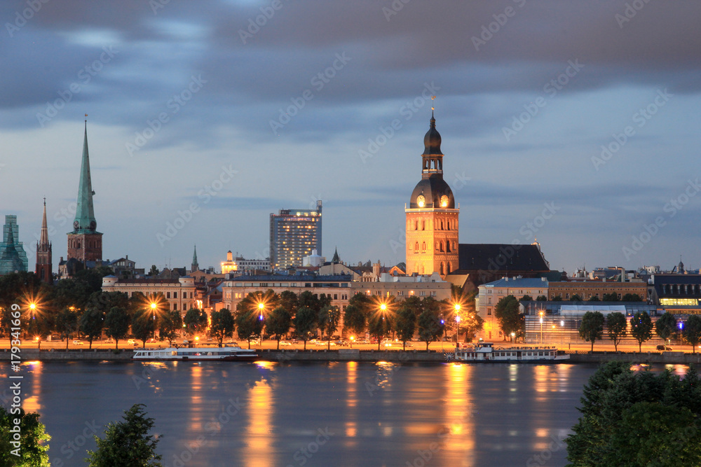 Panoramic view of Old Riga, Latvia at blue hour with street light reflection in the river Panoramic view of Old Riga, Latvia at blue hour with street light reflection in the river