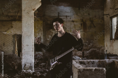 Caucasian man playing guitar in rubble