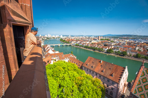 Young attractive man enjoying the view to old city center of Basel from Munster cathedral, Switzerland, Europe. photo