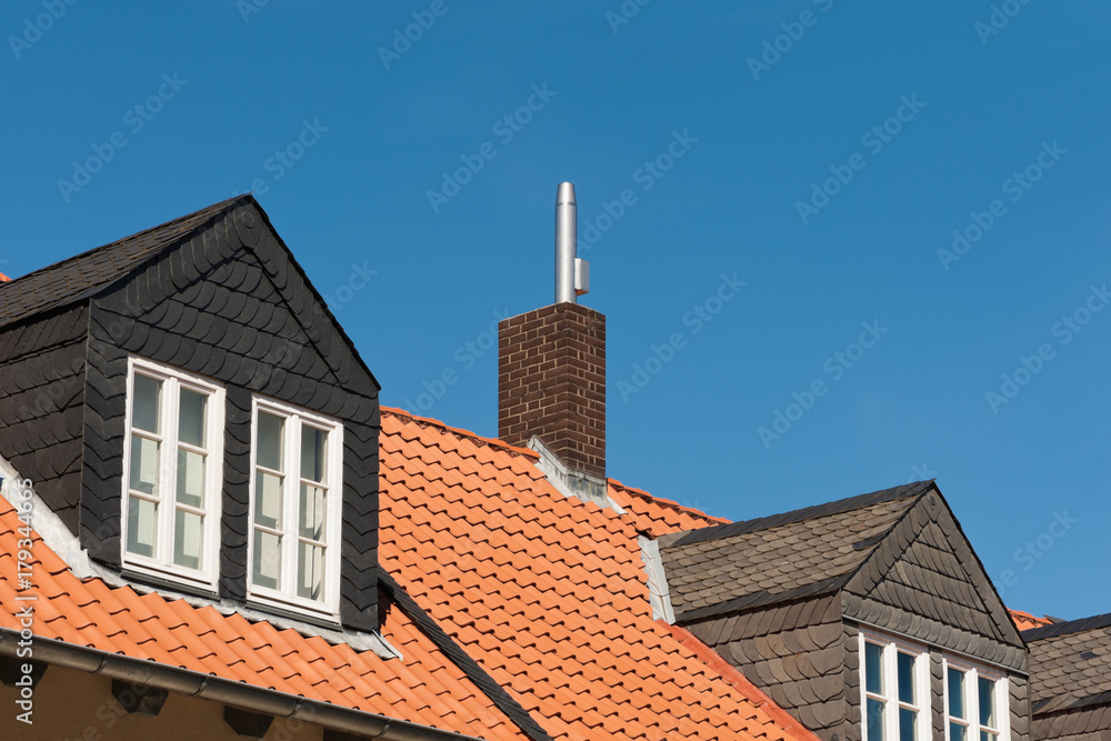 Mit Schiefer verkleidete Gauben in einem Dach mit Tonziegeln Mit Schiefer verkleidete Gauben in einem Dach mit Tonziegeln