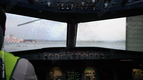 Pilot in cockpit flying. The interior of the aircraft cabin with the panel and steering wheel. The technician in the cockpit photo