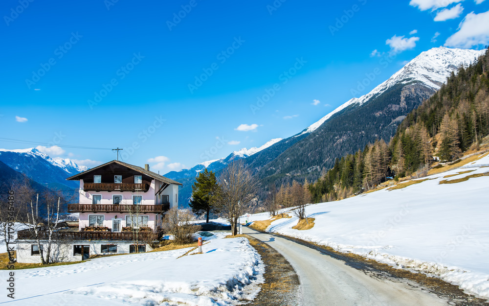 Amazing view of winter wonderland mountain scenery with traditional mountain chalet in the Alps on a sunny day with blue sky