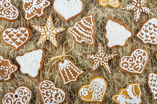 Homemade christmas gingerbreads on wooden boards and straw, the Christmas or New Year background