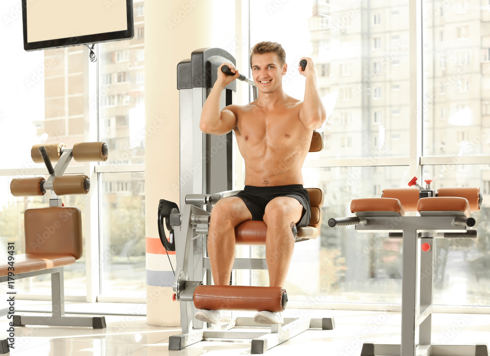 Fototapeta premium Sporty young man training in gym