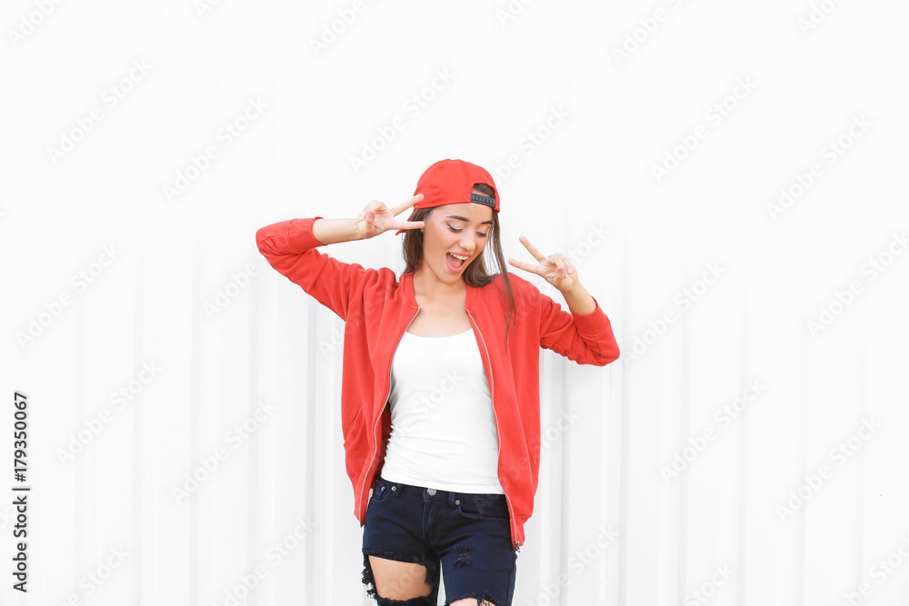 Attractive hipster girl posing near white wall