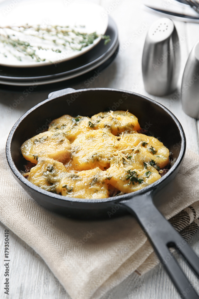 Frying pan with potato casserole on table Frying pan with potato casserole on table