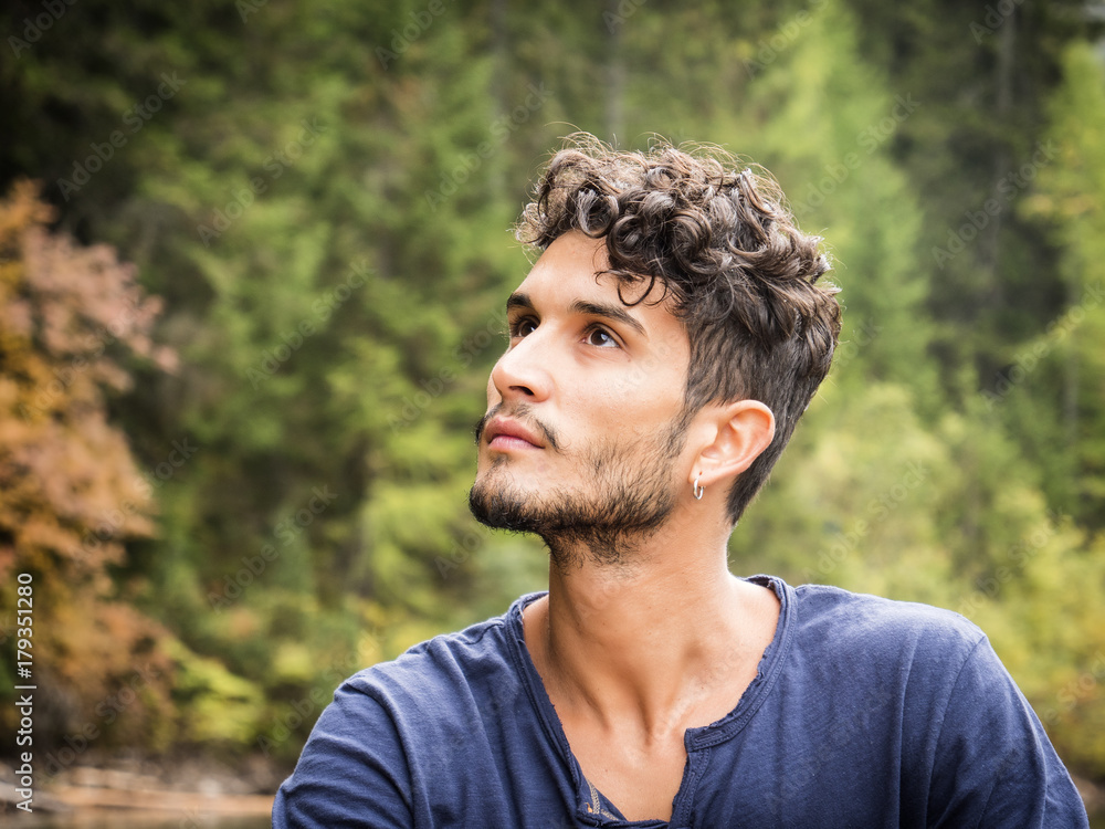 Handsome yung man standing on background of woods looking away. Handsome yung man standing on background of woods looking away.