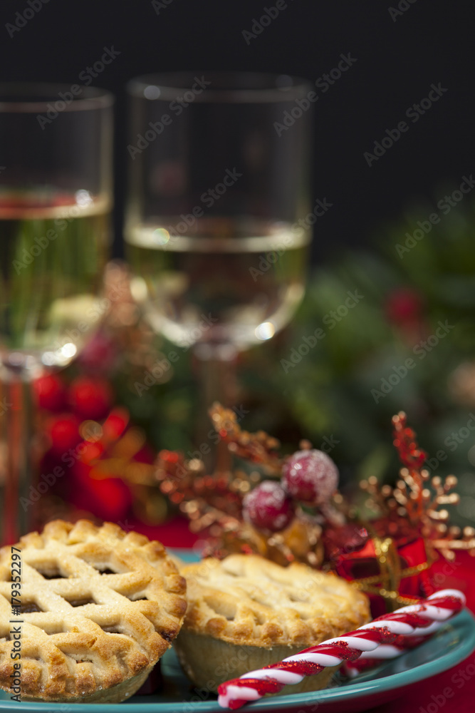 Mince pies a wine glasses on a table decorated for christmas