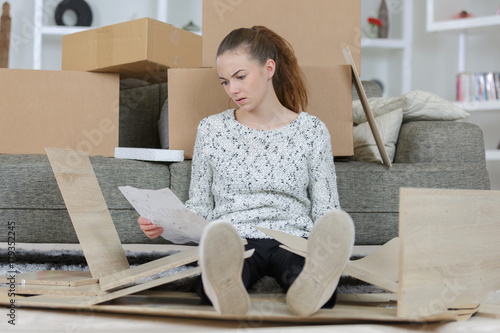 frustrated woman with self assembly furniture in kitchen photo