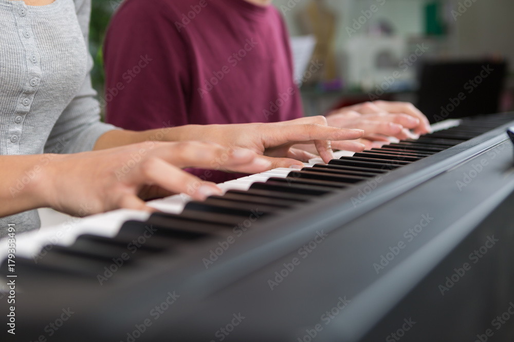 Fototapeta premium playing piano four hands close-up