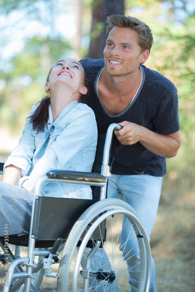man strolling with the handicapped woman in the woods man strolling with the handicapped woman in the woods
