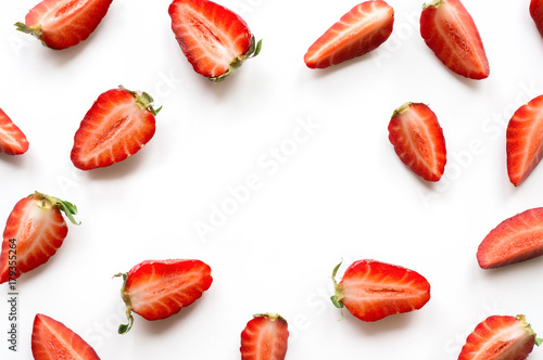 Strawberry pattern with copy space. Sliced ripe red berry on white background. Overhead view. 