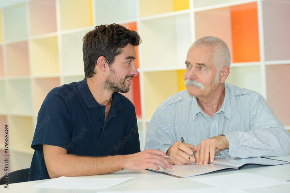 senior businessman offering proposal to young man