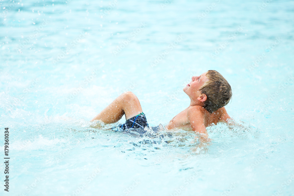 Boy playing at a waterpark pool