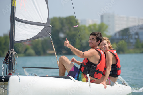 young couple steering a catamaran © auremar