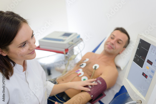 doctor measuring blood pressure of patient with electrodes