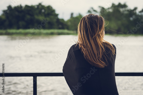 Lonely woman sitting and looking at the river