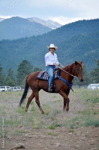 Middle-Aged Cowgirl on Brown Horse © Robiny