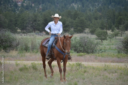 Middle-Aged Cowgirl on Brown Horse