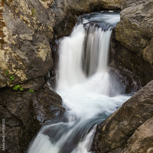 Close up mountain waterfall fast rushing water.