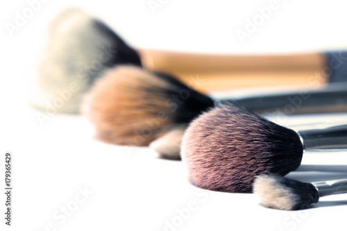 Various sizes and shapes of makeup brushed in isolated white background