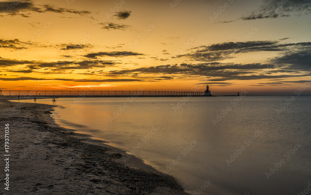 Lighthouse by the beach at sunset sky on Lake Michigan, Indiana, USA. Lighthouse by the beach at sunset sky on Lake Michigan, Indiana, USA.